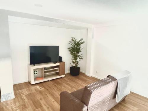 a living room with a couch and a flat screen tv at Figueira Luxury Comfort House in Figueira da Foz