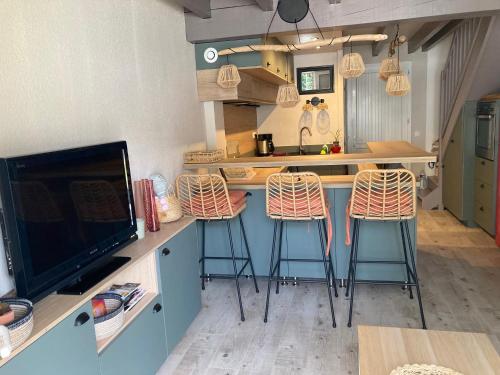 a kitchen with three bar stools at a kitchen counter at RESIDENCE LA CROISIERE- Appt Duplex 6 Personnes in Anglet