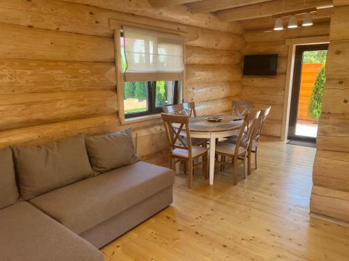 a living room with a couch and a table and chairs at Smerekovyi Dvir in Polyana