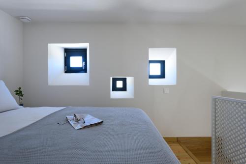a bedroom with a bed and three pictures on the wall at ANOTERRA VILLAS -Astris in Ambelas