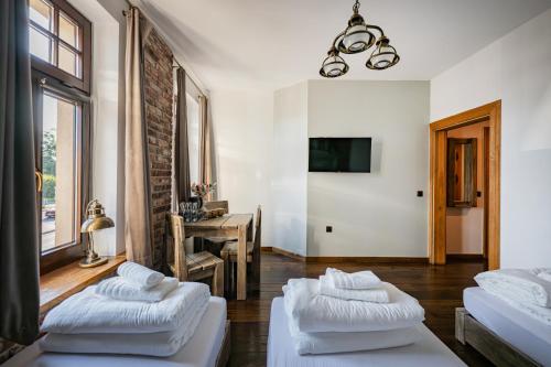 a living room with three beds and a table at Stara Przepompownia in Ostrów Wielkopolski
