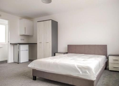 a bedroom with a large bed and a kitchen at City breaks Corby Uist Walk in Rockingham