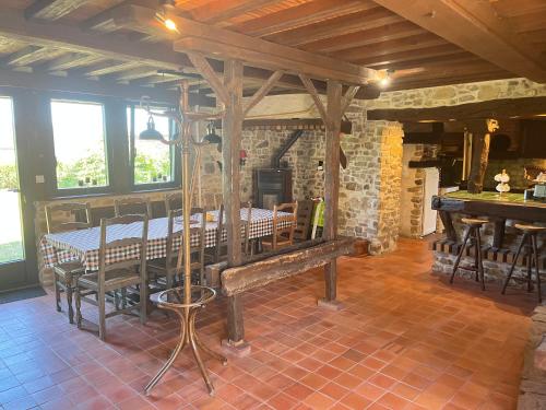 une salle à manger avec une table et un mur en pierre dans l'établissement Le gîte de Pommette et Billy, à La Hoguette