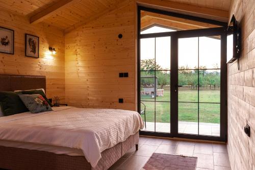 a bedroom with a bed and a large window at Nina in Golubovci