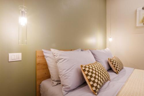 Bett mit vier Kissen auf einem Zimmer in der Unterkunft Urban Eden Nest - Smart Oasis in the Motor Valley in Modena