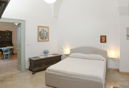 a bedroom with a white bed and a table at Corte delle rondini in Calimera