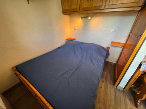 Ce lit se trouve dans un dortoir doté d'un drap bleu. dans l'établissement Résidence Median - Appartement équipé pour 4 personnes aux Ménuires MAE-5544, aux Menuires