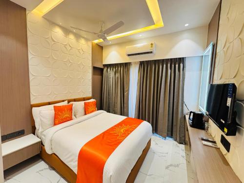 a bedroom with a bed and a flat screen tv at Hotel Sun-n-Moon in Shirdi