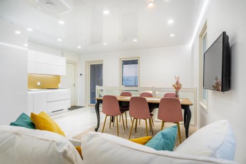 a kitchen and dining room with a table and chairs at Modern apartment with jacuzzi and sauna in Vaasa