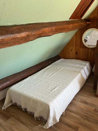 - un lit dans une chambre avec un toit dans l'établissement Le gîte de Pommette et Billy, à La Hoguette