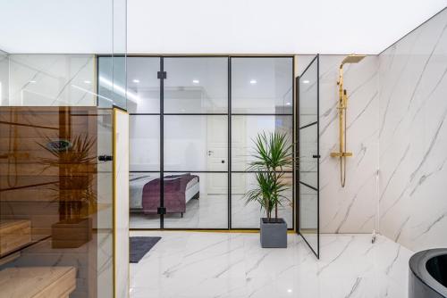 a room with glass walls and a bedroom with a bed at Modern apartment with jacuzzi and sauna in Vaasa
