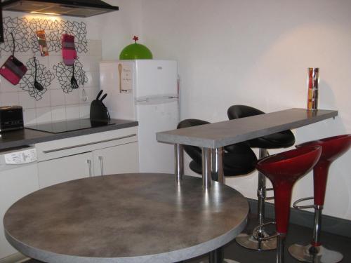 - une cuisine avec une table et des chaises rouges dans l'établissement city-break, à Épinal