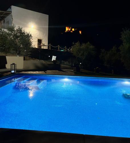 a large blue swimming pool at night at Casa Caraza. Un olivar con vistas al castillo de Juego de Tronos in Almodóvar del Río