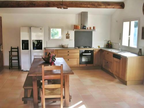 une cuisine avec une table en bois et une table et des chaises dans l'établissement Casa-Simone Les Vieilles Dalles de Pierre, à Malaucène