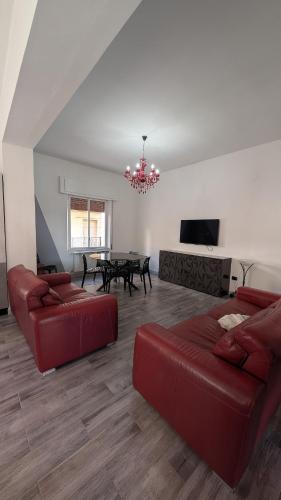 a living room with two red couches and a table at Casa Morgana, a 2 passi dal mare in Badolato Stazione