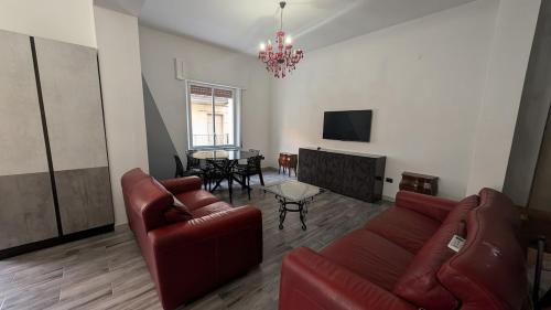 a living room with a red couch and a table at Casa Morgana, a 2 passi dal mare in Badolato Stazione