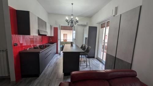 a kitchen with red cabinets and a black counter top at Casa Morgana, a 2 passi dal mare in Badolato Stazione