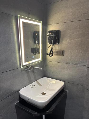 a bathroom with a sink and a mirror at Hotel Sun-n-Moon in Shirdi