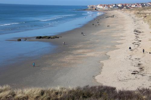 a group of people walking on a beach at Kaz Bohèm' in Ambleteuse