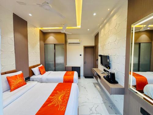 a hotel room with two beds and a television at Hotel Sun-n-Moon in Shirdi