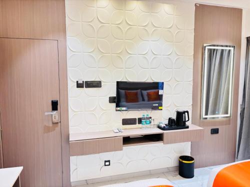 a hotel room with a tv on a wall at Hotel Sun-n-Moon in Shirdi