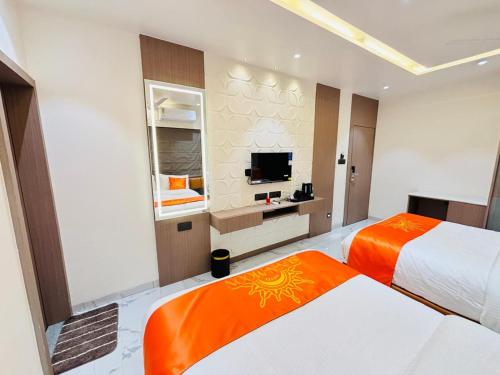 a hotel room with two beds and a flat screen tv at Hotel Sun-n-Moon in Shirdi