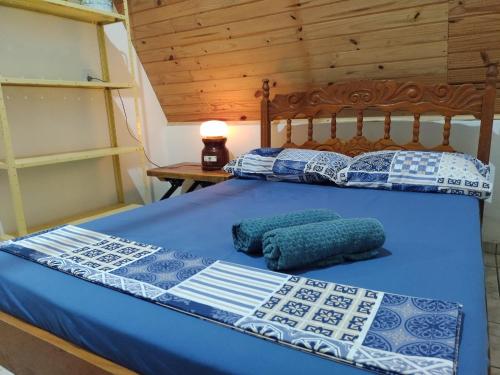 a bed with blue sheets and pillows on it at Recanto Efraim in Tapiraí