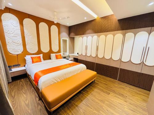 a bedroom with a bed in a room with windows at Hotel Sun-n-Moon in Shirdi