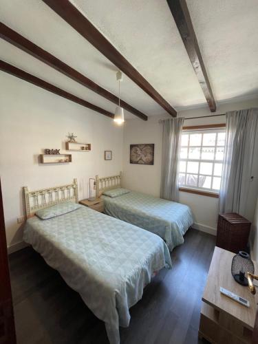 a bedroom with two beds and a window at Casa Brisa Abades in Abades