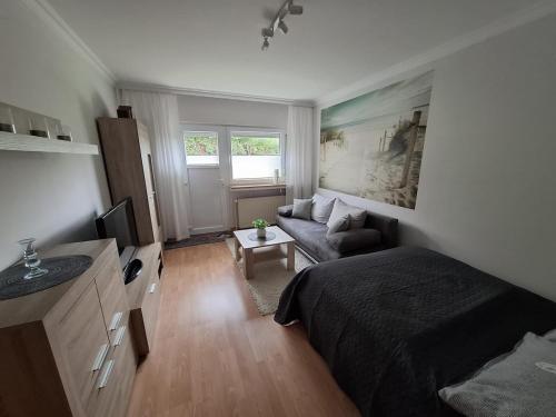 a small bedroom with a bed and a couch at Fewo Apartment "Zur Düne" in Langelohe