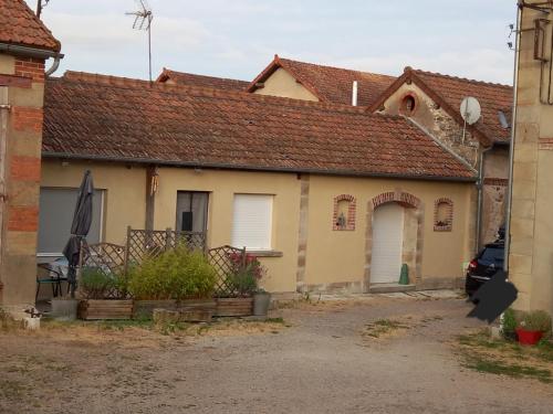 une vieille maison avec un toit rouge dans l'établissement Gîte de la Queune 50 m2, à Souvigny