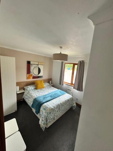 un dormitorio con una cama y una ventana en Hawthorn Lodge, en Fort William