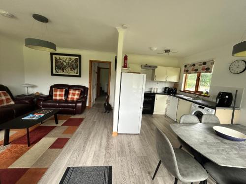 a kitchen and living room with a table and a refrigerator at Hawthorn Lodge in Fort William