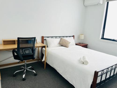 a bedroom with a bed and a desk and a chair at Rooms to share In heart of Asian Vietnamese area in St Albans