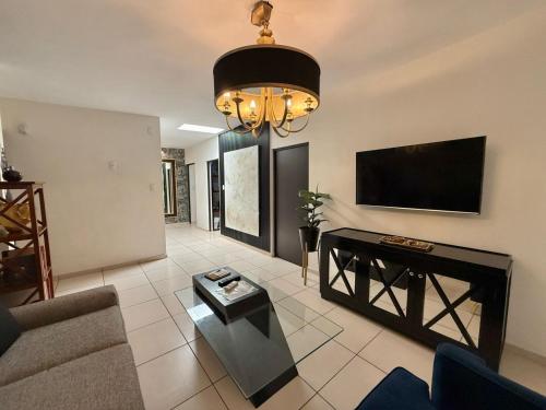 a living room with a couch and a flat screen tv at Escala HMO a700 mts del Consulado americano in Hermosillo