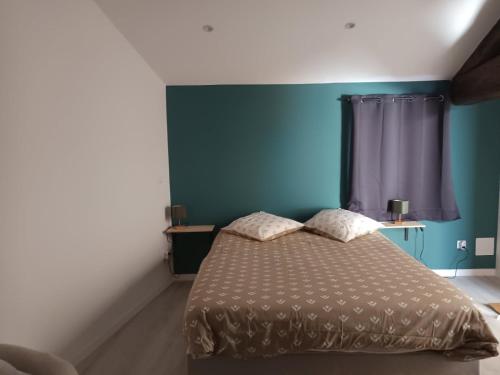 a bedroom with a bed with a blue wall at appartements familial in Vias