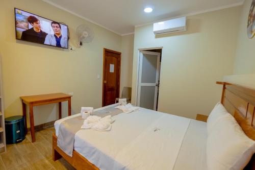 a bedroom with a bed with a tv on the wall at Hotel El Tambo de Tarapoto-Perú in Tarapoto