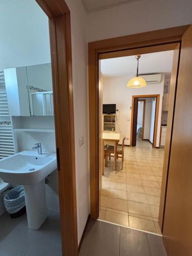 baño con lavabo y cocina con mesa. en Appartamenti CALDERONE, en Rímini