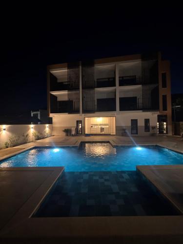 a swimming pool in front of a building at night at Harmony House - Adults Only in Dubova