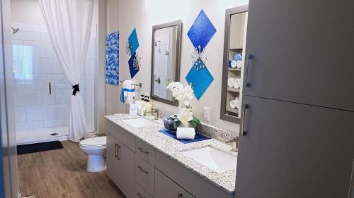 a bathroom with a sink and a toilet and a mirror at Blue Waves Serenity 1BD Lux King - Southeast Jax in Jacksonville