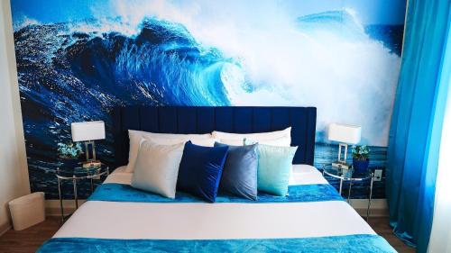 a bedroom with a large wave painting on the wall at Blue Waves Serenity 1BD Lux King - Southeast Jax in Jacksonville