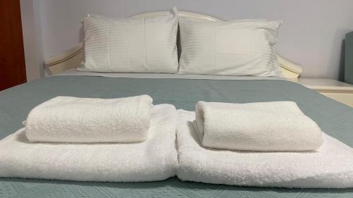 two stacks of towels sitting on top of a bed at Relax in Loutraki in Loutraki
