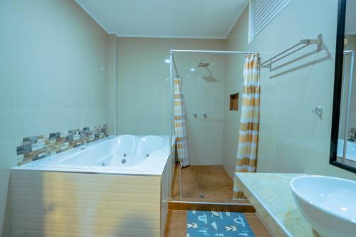 a bathroom with a tub and a sink at Hotel El Tambo de Tarapoto-Perú in Tarapoto