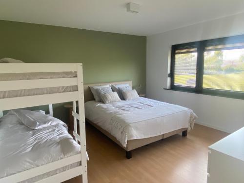 a bedroom with two bunk beds and a window at Vakantiewoning Ten Huyze Bucholt met tuinsauna in Bocholt