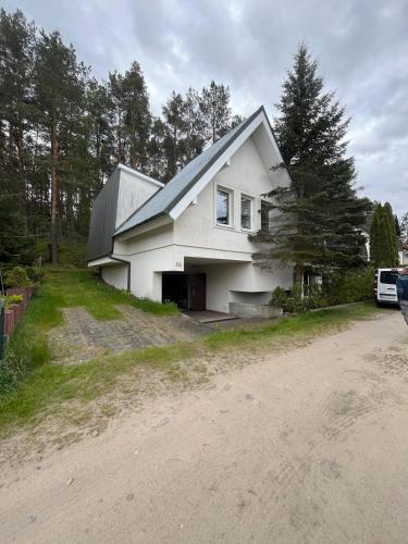 a white house with a garage on a dirt road at PANORAMA Małe Swornegacie in Małe Swornegacie