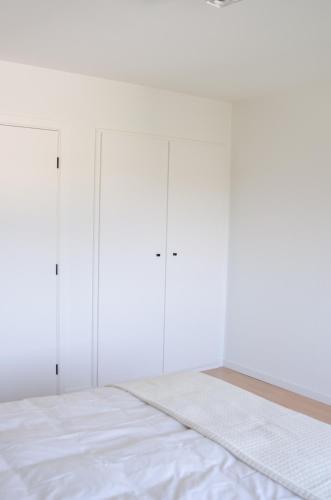 a white bedroom with four wardrobes at Vakantiewoning Ten Huyze Bucholt met tuinsauna in Bocholt