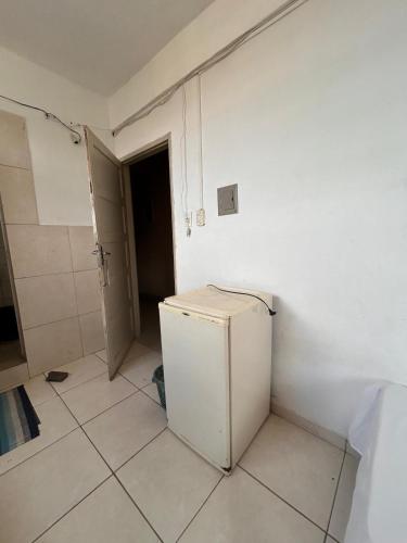 a kitchen with a white refrigerator in a room at Hotel Minas in Itamaraju