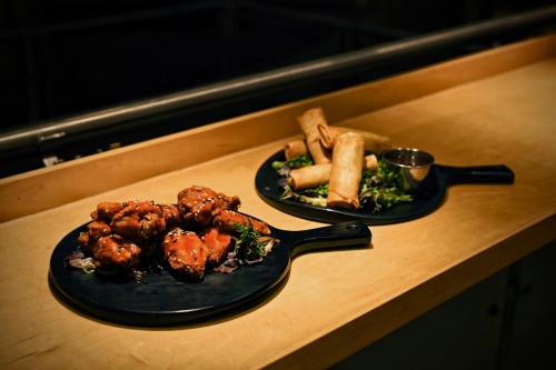 two plates of food sitting on a counter with a plate of food at iHOTEL & Conference Centre Red Deer in Red Deer