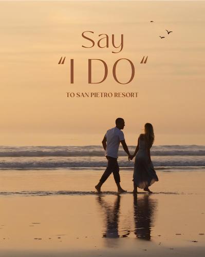 a man and woman walking on the beach at sunset at ToSea Apartment by Melia in Lalzit Bay