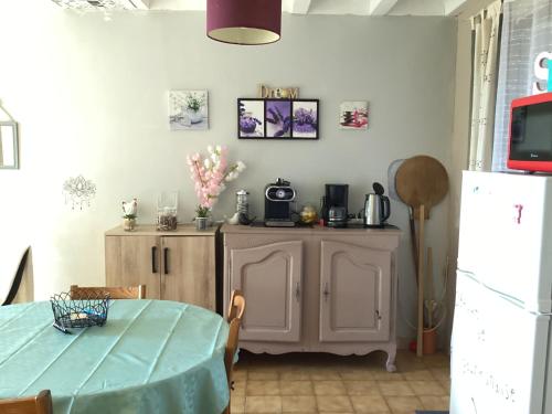 une salle à manger avec une table et un réfrigérateur dans l'établissement 196 rue des moulins, à Vachères